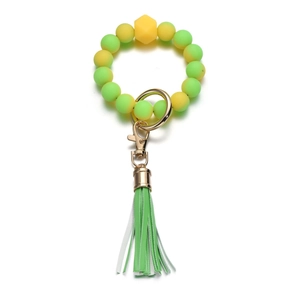 Dettaglio portachiavi con perle in silicone giallo e verde neon, chiusura oro e nappa