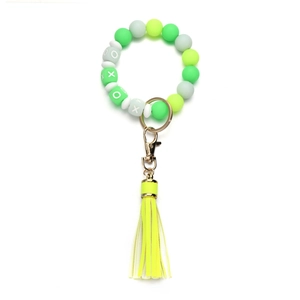 Detail of beaded silicone keychain with yellow tassel and gold-tone lobster clasp