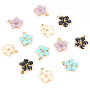 Detailed macro view of colorful enamel flower charms with gold edges for DIY jewelry making