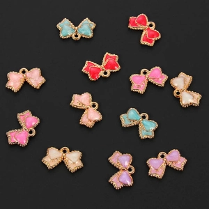 Macro detail of colorful bow-knot charms with gold-edged enamel and top hanging rings