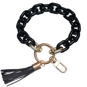 Detail showing the black acrylic chain, golden lobster clasp, and black PU tassel