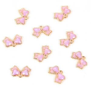 Close-up of nine light purple bow pendants with gold edges for jewelry making