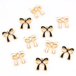 Detailed macro view of black and white enamel bowknot charms for DIY jewelry making
