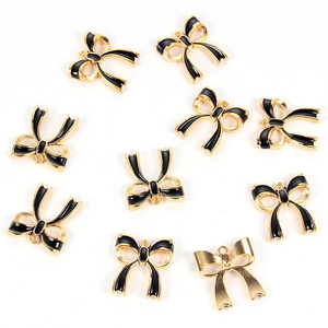 Detailed macro view showing the front and back of black enamel bow jewelry charms