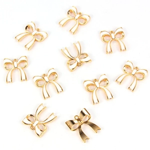 Detailed macro view of ten white enamel bow alloy charms with golden metal edges