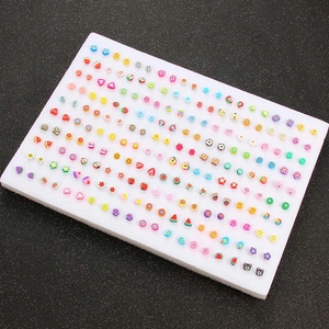 Detailopname van een set acryl oorknopjes met verschillende fruitmotieven en smileys