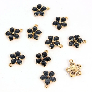 Close-up of black enamel flower pendants with gold plating for DIY jewelry making