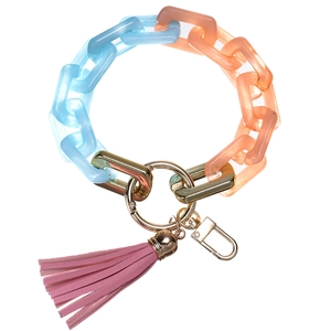Detail of light blue and orange acrylic bracelet keychain with pink leather tassel