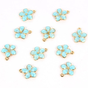 Close-up of light blue enamel flower charms with gold edges and loops for jewelry making
