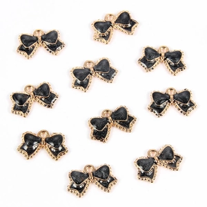 Detail of ten black glitter bow pendants with golden alloy edges for jewelry DIY