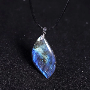Vue macro d'un pendentif labradorite en forme de feuille avec reflets bleus et cordon noir