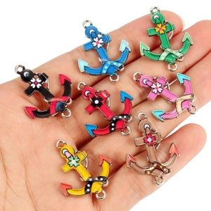 Detailed macro view of seven colorful enamel anchor charms on a palm for size reference