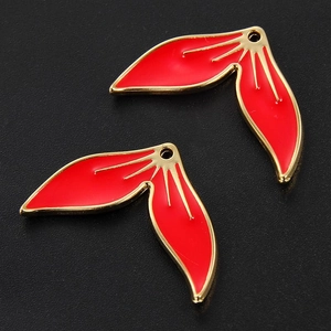 Macro detail of red enamel leaf charms with gold plating for jewelry DIY projects