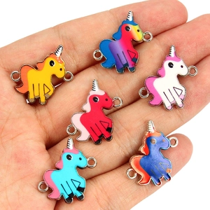Detail showing 6 colorful enamel unicorn charms for DIY bracelets held in a hand