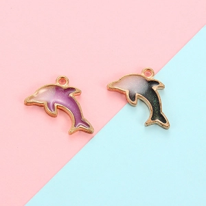 Detail of purple and grey gradient dolphin charms with gold metal edges for DIY jewelry