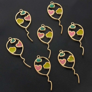 Detail of seven heart-shaped balloon alloy charms with colorful enamel on dark background