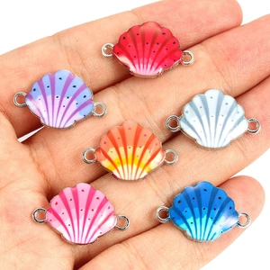 Close-up of colorful shell charms with enamel finish and silver connecting loops