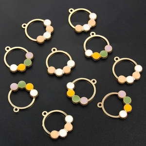 Detailed view of colorful enamel dot charms in gold frames for DIY jewelry