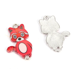 Detail view of red raccoon charm showing colorful enamel front and silver metal textured back