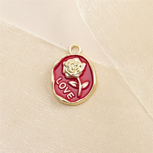Detailed close-up of oval red enamel rose pendant with golden LOVE relief for DIY jewelry