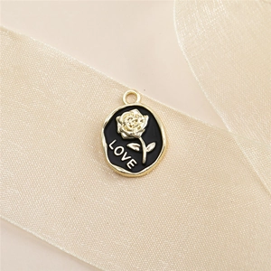 Macro shot of gold-plated rose charm with LOVE engraving on a soft ribbon background