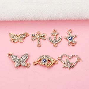Détail macro de sept connecteurs de bijoux papillon et libellule en strass dorés
