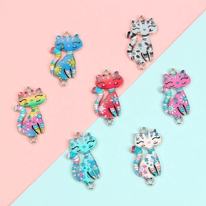 Close-up of colorful cat enamel charms with floral patterns for DIY jewelry making