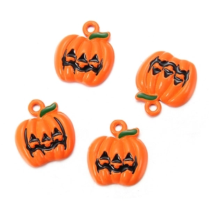 Detail van vier oranje emaille pompoenbedels met zwarte gezichten voor Halloween-doe-het-zelf