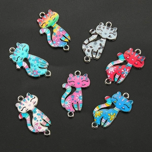 Macro shot of colorful enamel cat charms with floral patterns for DIY jewelry making