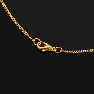 Macro detail of gold-plated copper cross chain featuring a secure lobster clasp