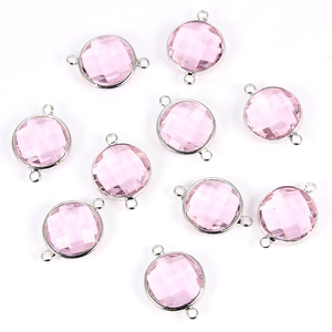Detailed view of faceted pink crystal round charms with silver metal connectors for DIY jewelry