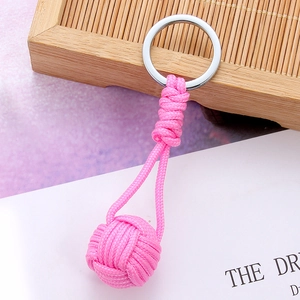 Detail of pink handmade woven rope keychain featuring a round knot and silver ring