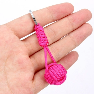 Detail view of handmade rose red paracord keychain with woven spiral pattern and metal ring