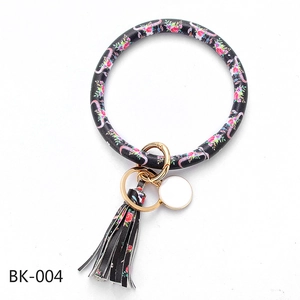 Detail of floral cow skull PU leather keyring with fringe tassel and golden hardware