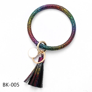 Detail of colorful glitter PU leather bracelet keychain with fringe tassel and gold hardware