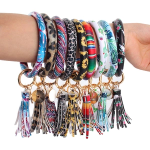 Set mit 10 Schlüsselanhänger-Armbändern aus PU-Leder mit Blumenmustern am Arm getragen