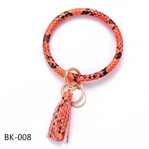 Detailed view of orange and black snakeskin PU leather ring keychain with tassel charm