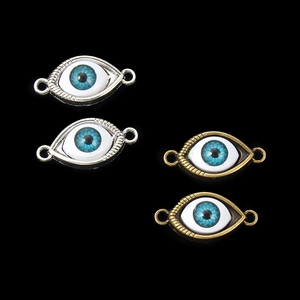 Detailed view of silver and bronze evil eye connector charms for DIY jewelry making