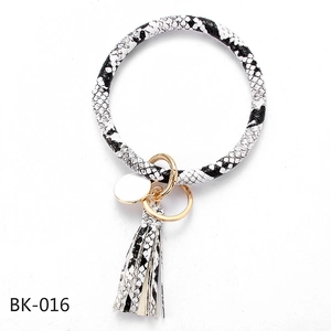 Detail of black and white snakeskin PU leather keychain bracelet with tassel and gold ring