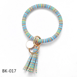 Close-up of multi-color striped PU leather keychain bracelet with tassel and round pendant