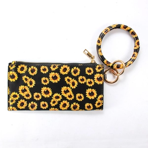 Detail of sunflower print PU leather pouch with golden zipper and circular bangle keychain