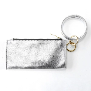 Detail view of silver textured leather coin purse with golden zipper and metal ring