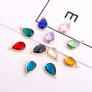 Close-up of teardrop-shaped faceted glass crystal pendants with golden metal frames