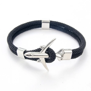 Détail d'un bracelet en paracorde noire tressée avec un fermoir en forme d'avion argenté