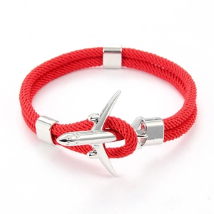 Détail du bracelet en paracorde rouge avec un fermoir en métal argenté en forme d'avion