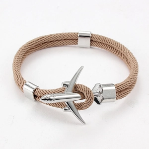 Détail du bracelet en paracorde marron avec fermoir en forme d'avion argenté poli