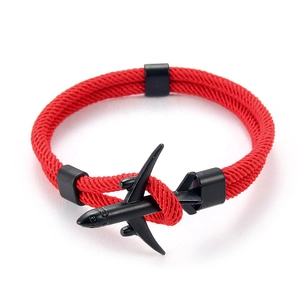 Gros plan sur un bracelet paracorde rouge avec pendentif avion noir et fermoir