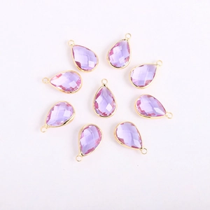 Detailed macro view of eight faceted purple crystal teardrop pendants with gold metal frames