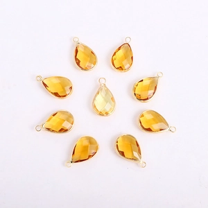 Detail of eight yellow teardrop-shaped faceted glass pendants with gold metal frames