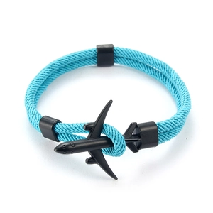 Vue détaillée du bracelet en paracorde bleu ciel doté d'un pendentif avion noir mat